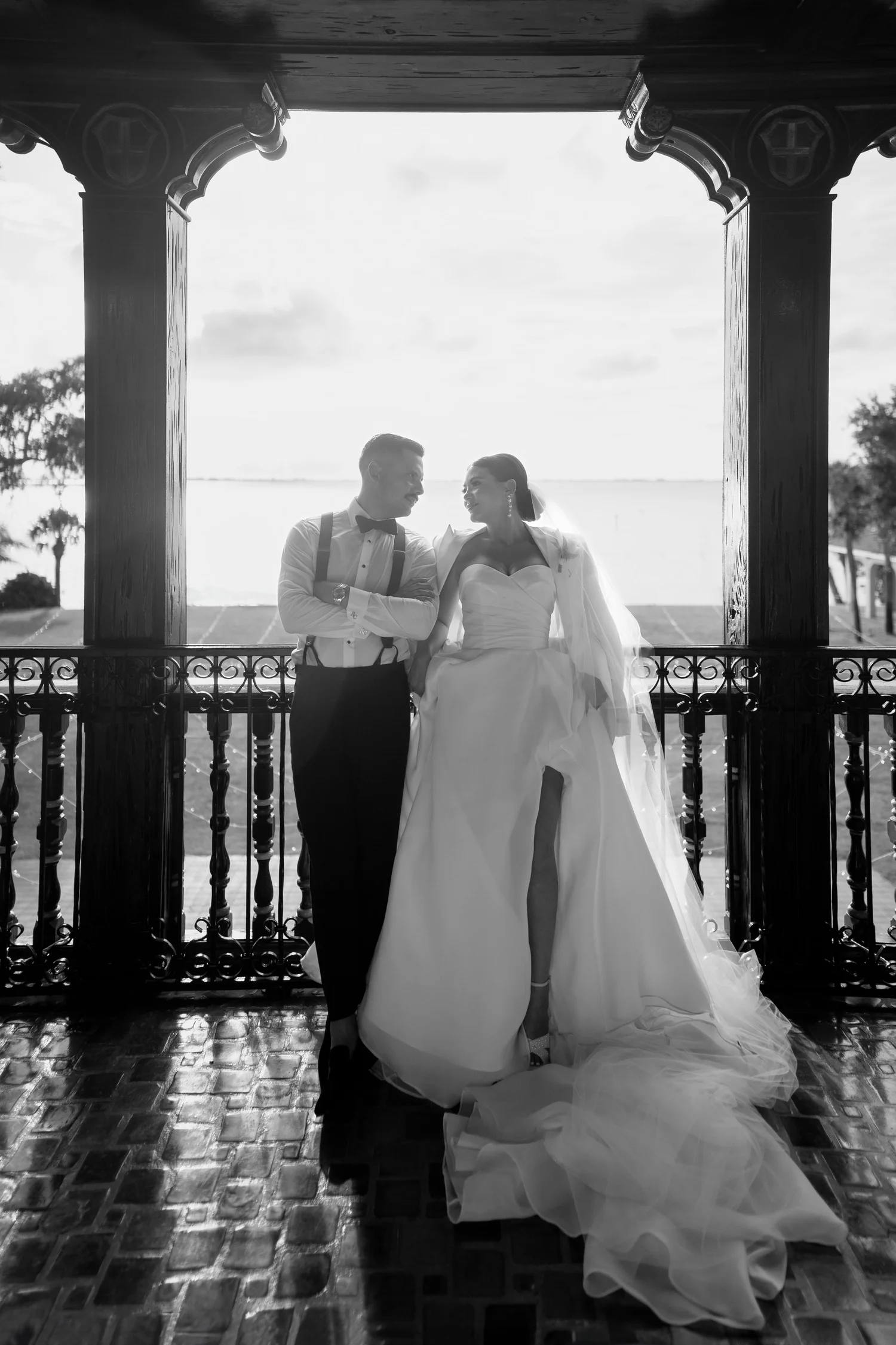 Black and white portrait of a bride and groom on a balcony