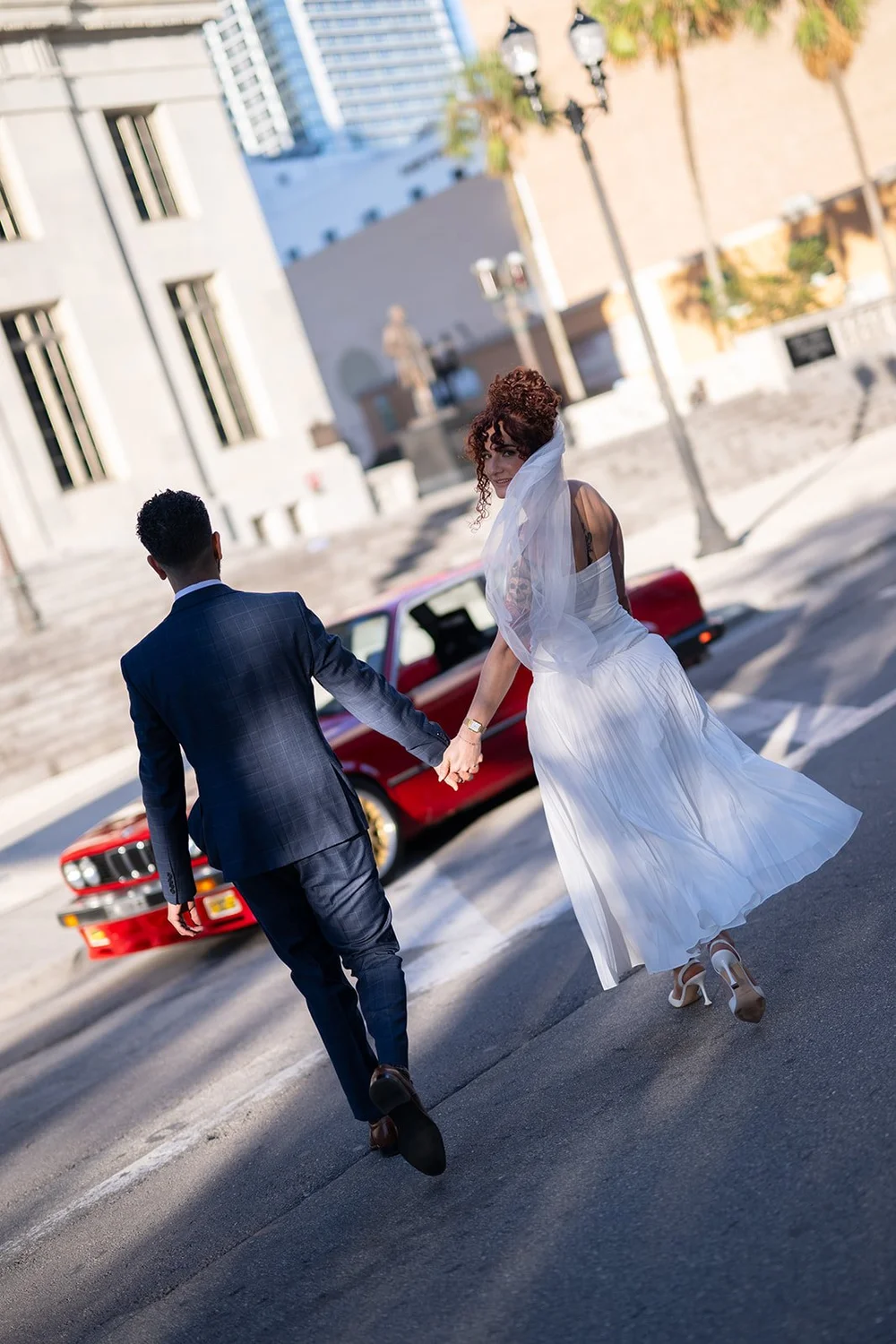 Bride and groom walking down a downtown Miami street