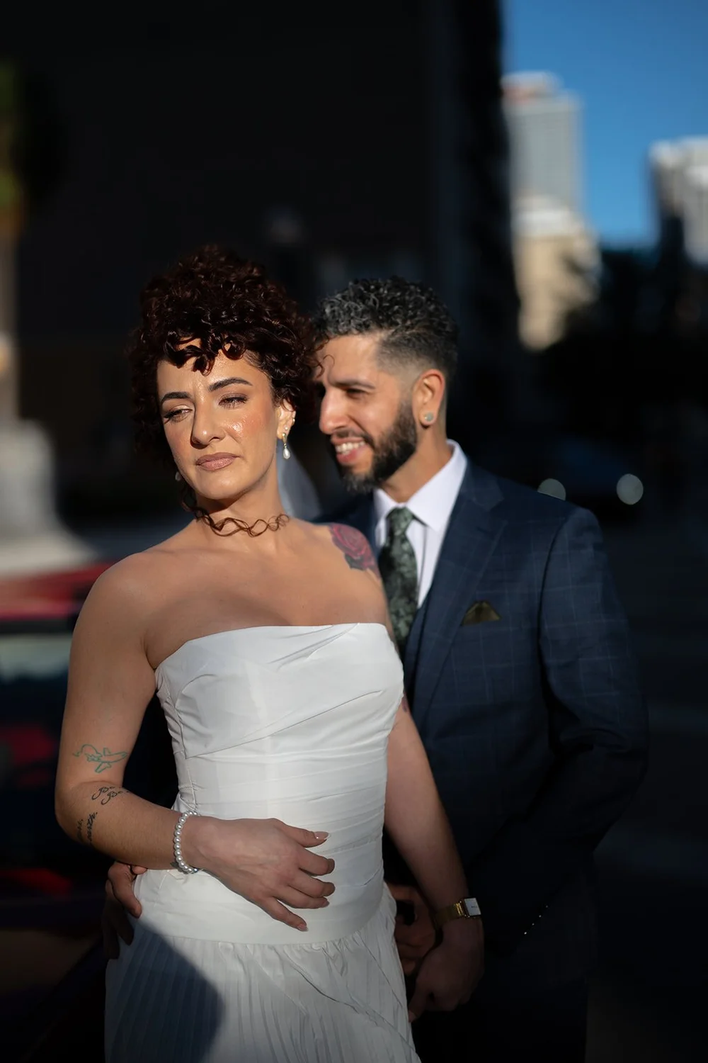 Bride in a strapless white dress and groom in a navy suit, portrait in downtown Miami
