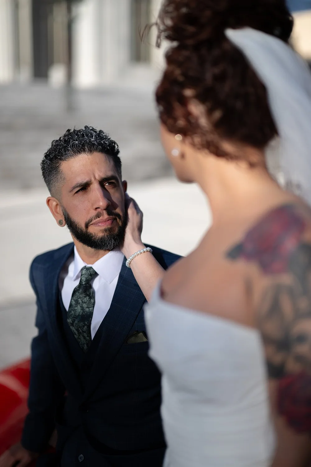 Close portrait of the groom and bride in front of a red car