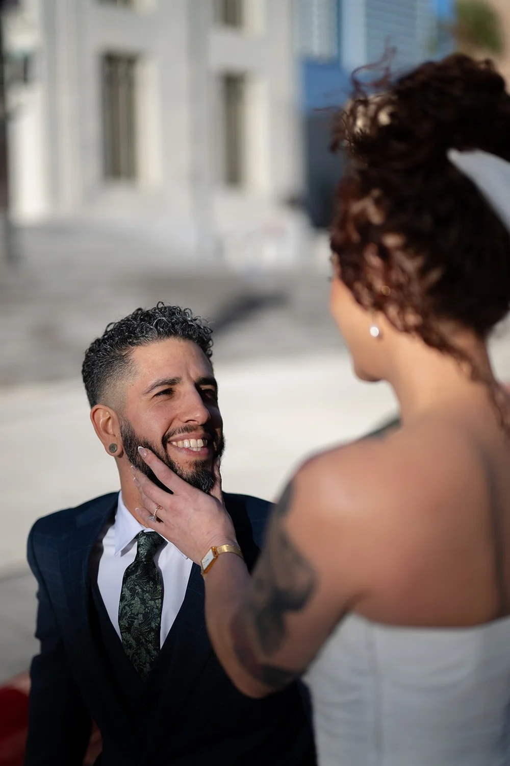 Bride touching the groom's face as he smiles