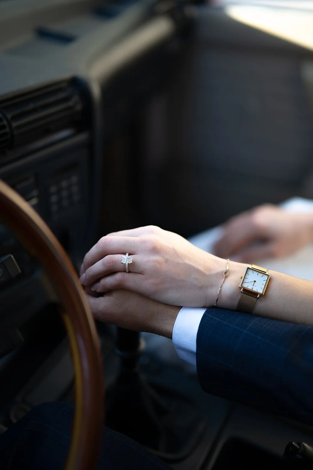 Detail of the groom's hands on the steering wheel of the red BMW