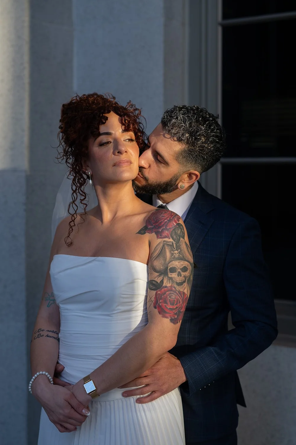 Groom kissing the bride's cheek in soft evening light