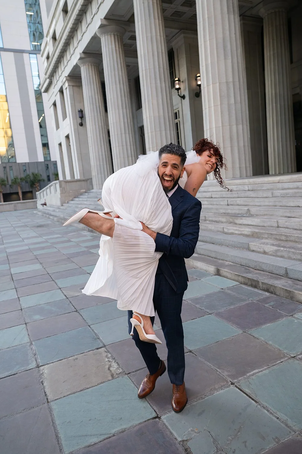 Groom dipping the bride on a patterned stone plaza
