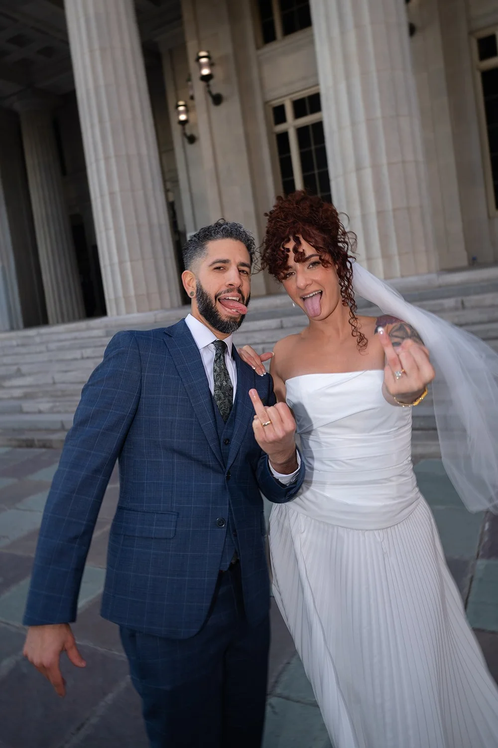 Bride and groom smiling at the camera in a wide-angle portrait