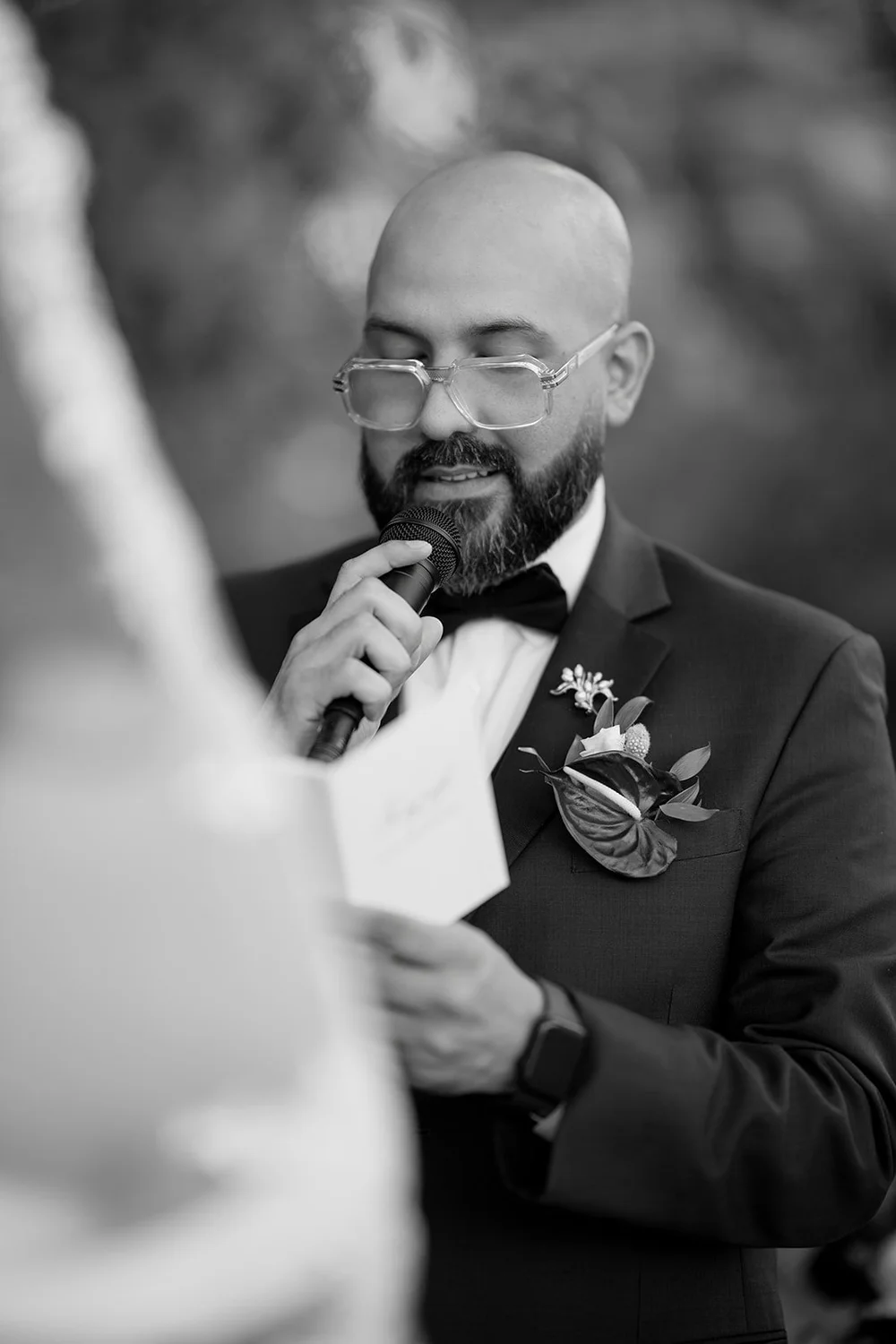 Christian reading from a card during the ceremony, in black and white