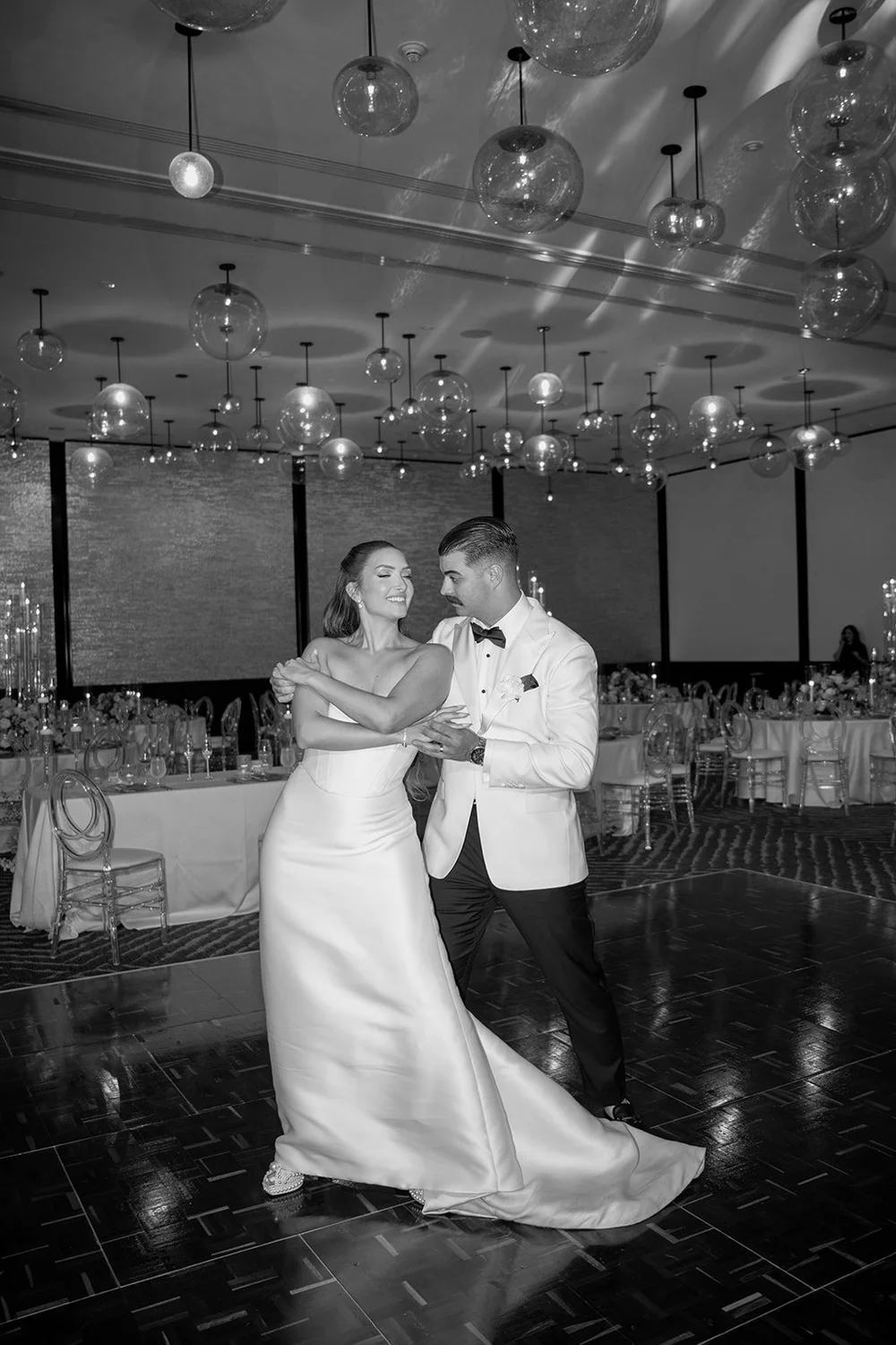 Rachel and Austin sharing their first dance on the ballroom floor, in black and white