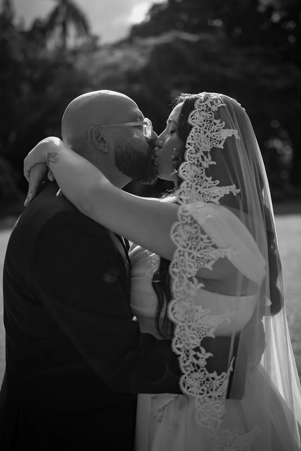 Christian and Maria embracing and kissing on the lawn, in black and white