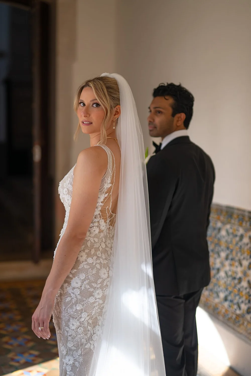 Ellen in her veil looking over her shoulder next to Jacob in soft window light