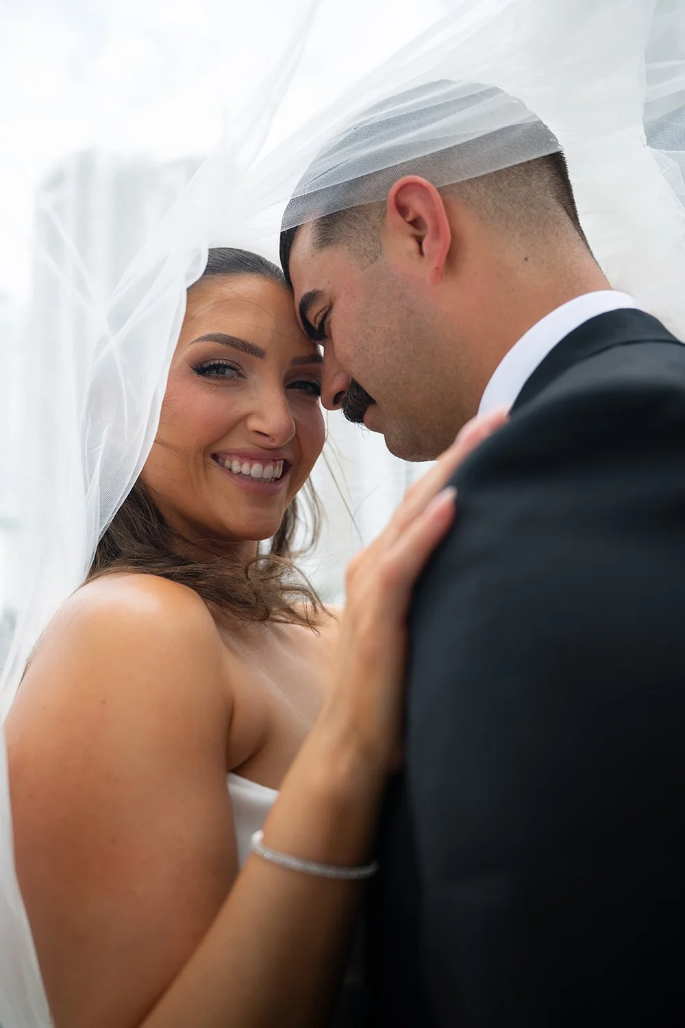 Close portrait of Rachel and Austin together under her veil