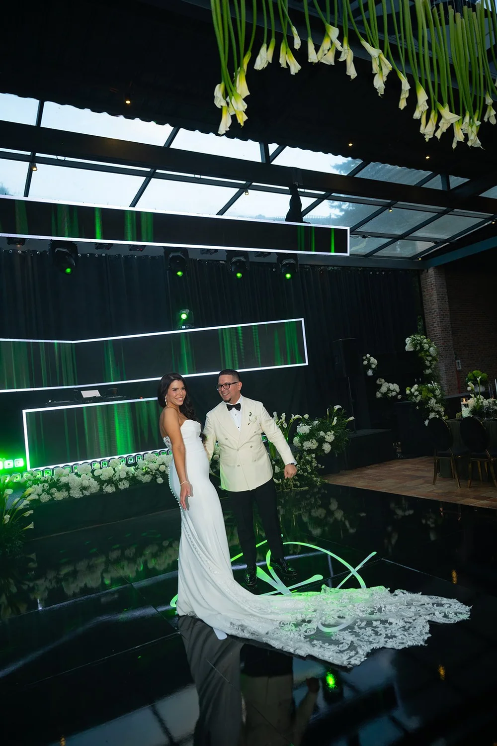Krystine and Douglas in the reception room under green lights and a glass ceiling