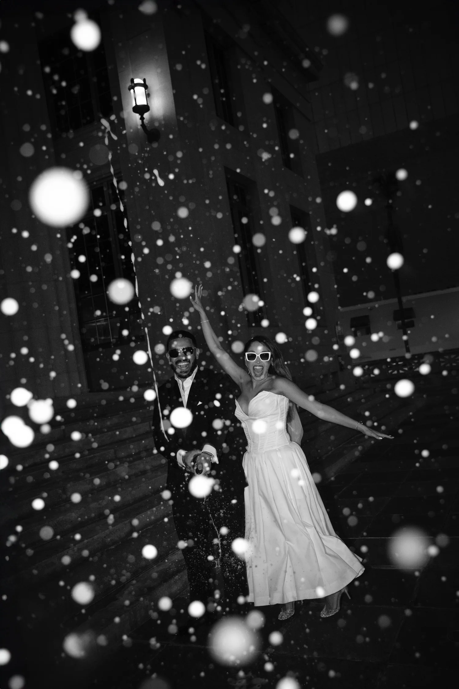 Bride and groom dancing under falling confetti