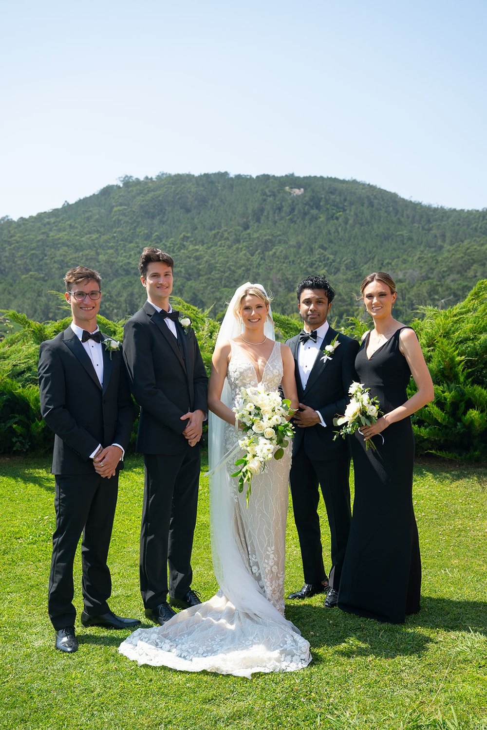 Ellen and Jacob with the wedding party lined up on the lawn