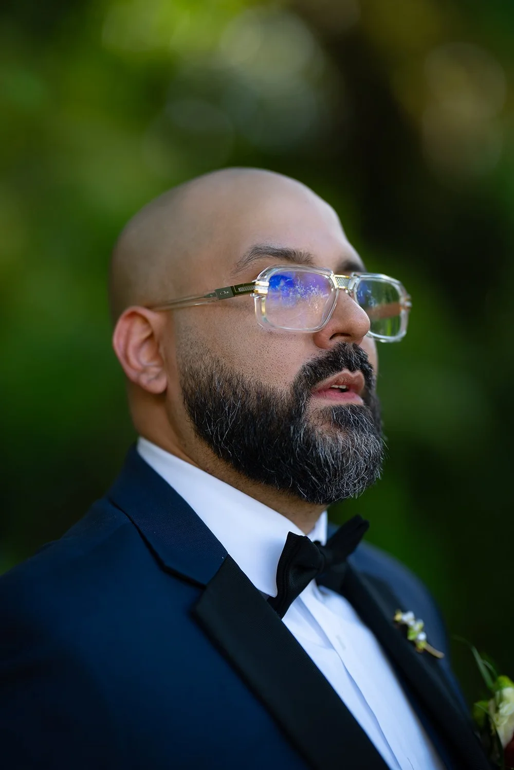 Close portrait of Christian in glasses and a bow tie waiting for the ceremony to start
