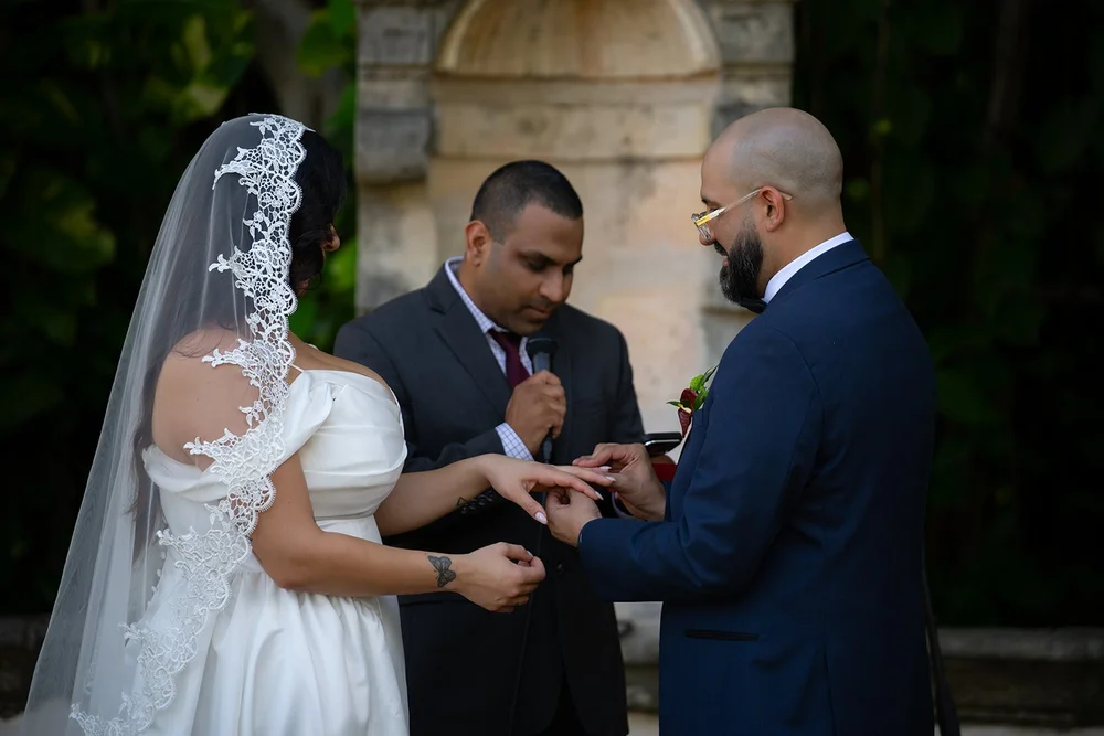 Maria and Christian exchanging rings in front of the officiant