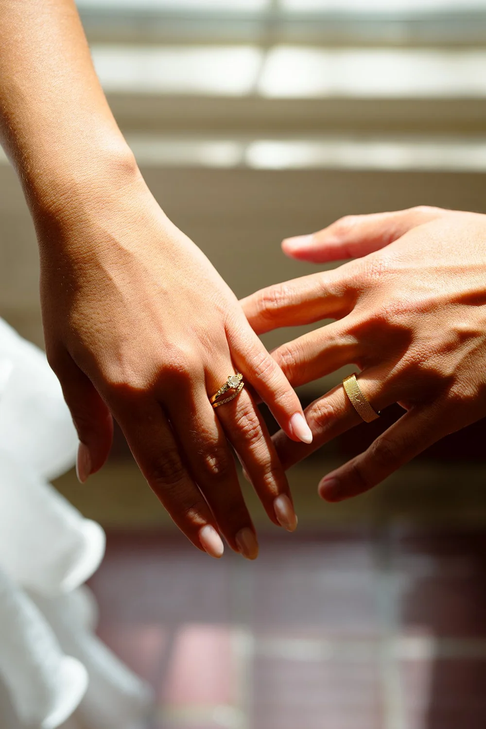 Color close-up of the couple's hands touching with a wedding ring visible