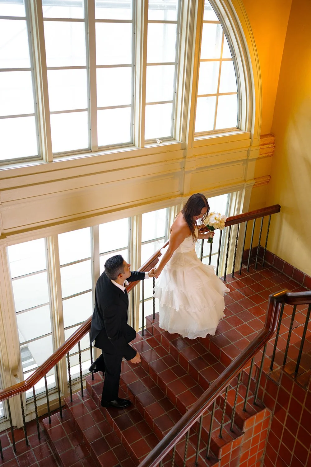David walking up the stairs toward Chris beneath large arched windows