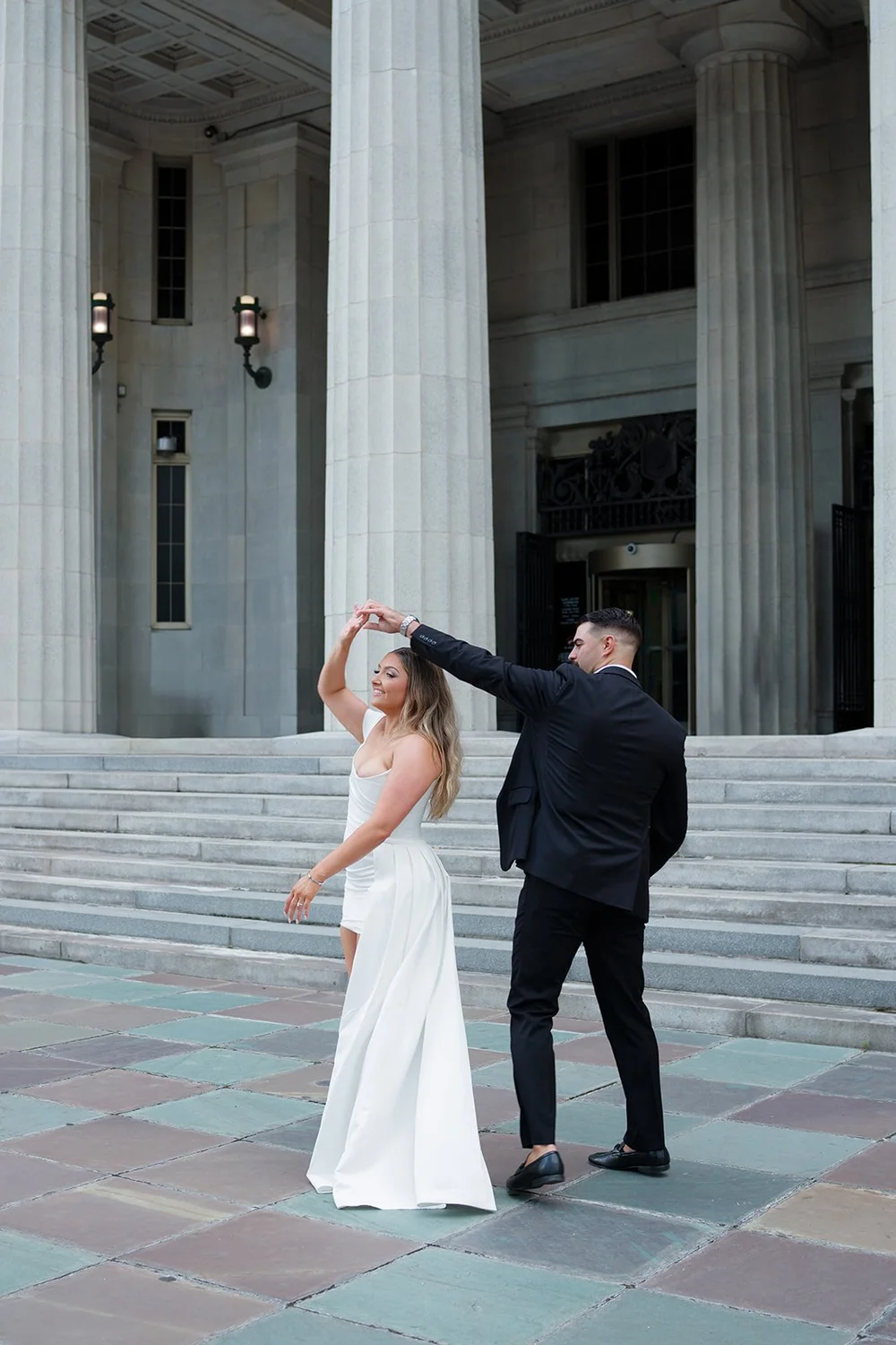 Austin spinning Rachel on the courthouse steps between tall stone columns
