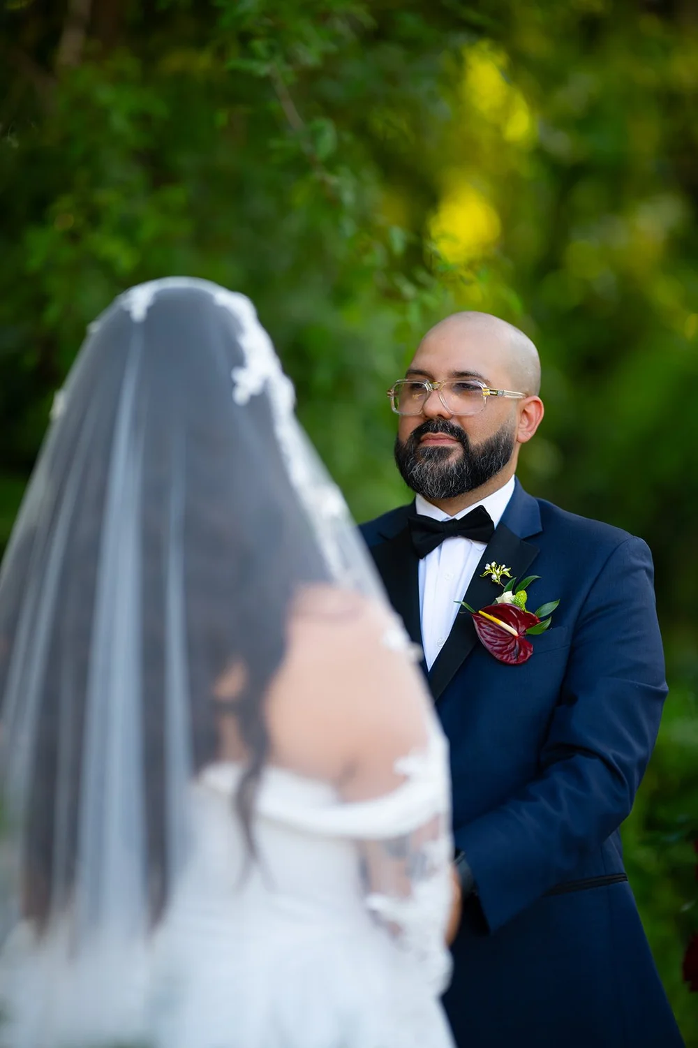 Christian smiling at Maria during the ceremony in the gardens