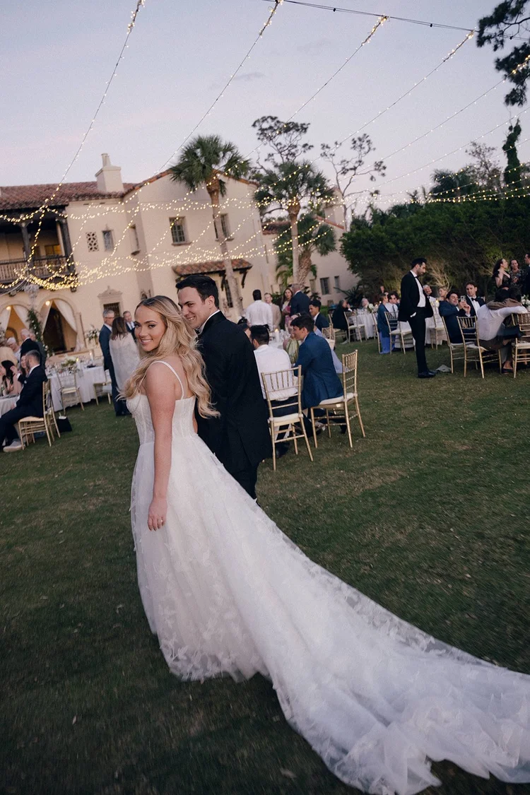Film photo of Jane walking across the lawn in front of the estate with guests gathered at tables