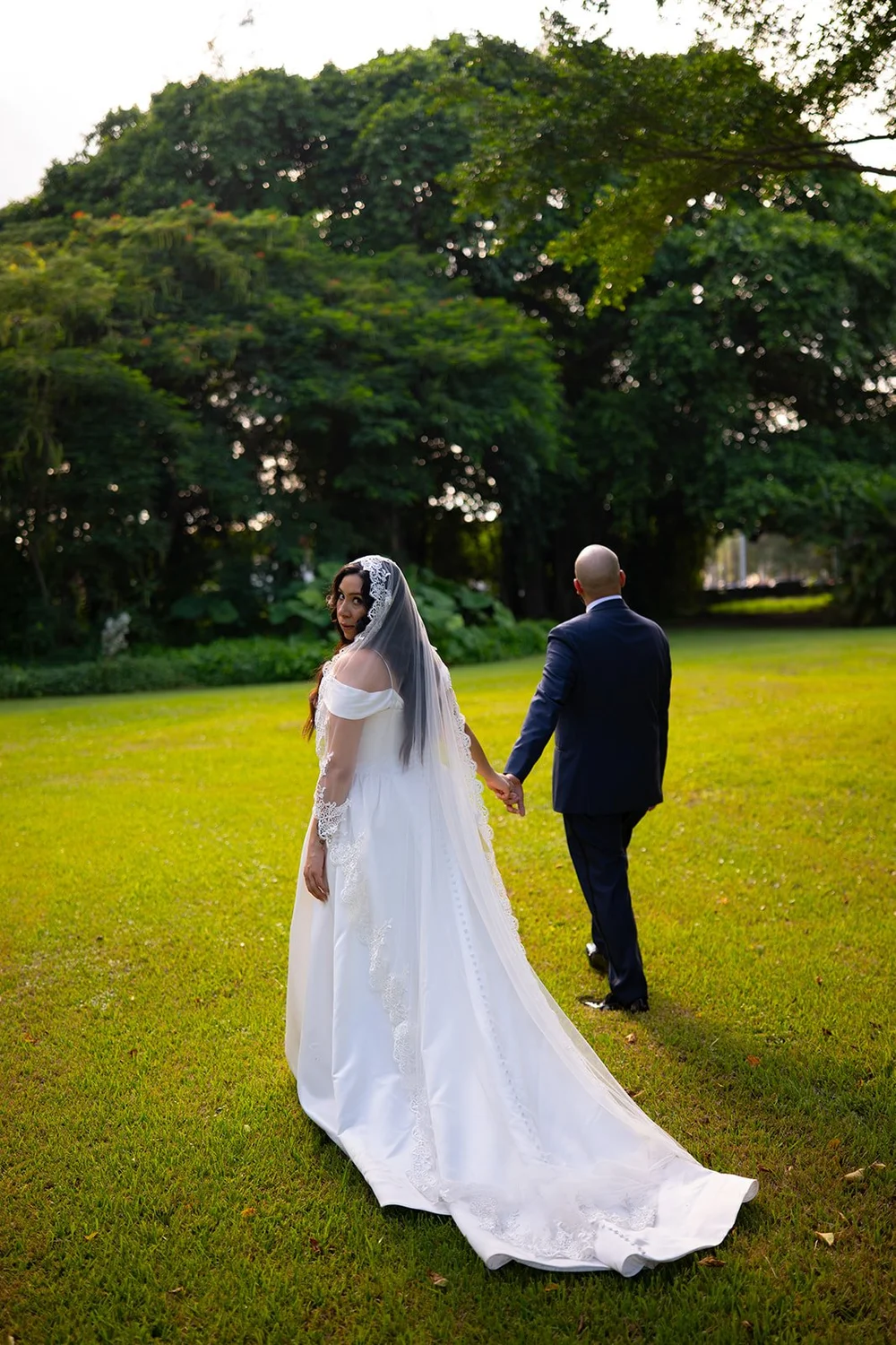 Maria and Christian walking across the green lawn of the monastery gardens