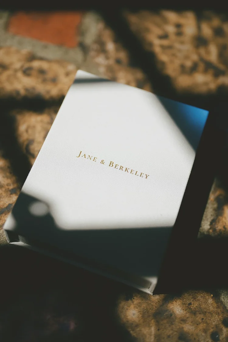 Film photo of a wedding invitation box with the names Jane and Berkeley in gold letters