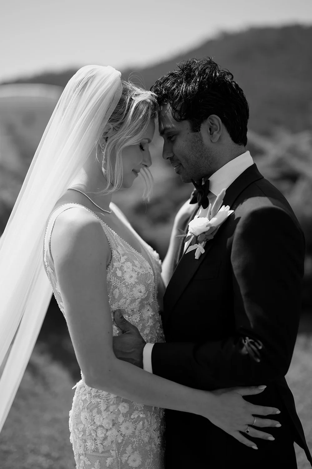 Black and white photo of Ellen and Jacob pressing their foreheads together on the lawn