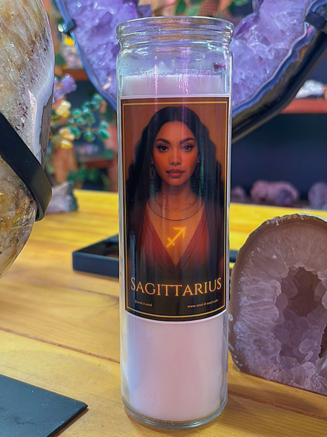 Sagittarius zodiac ritual candle by Soul II Soul featuring a goddess with long flowing hair and a glowing Sagittarius symbol, in a candle jar.