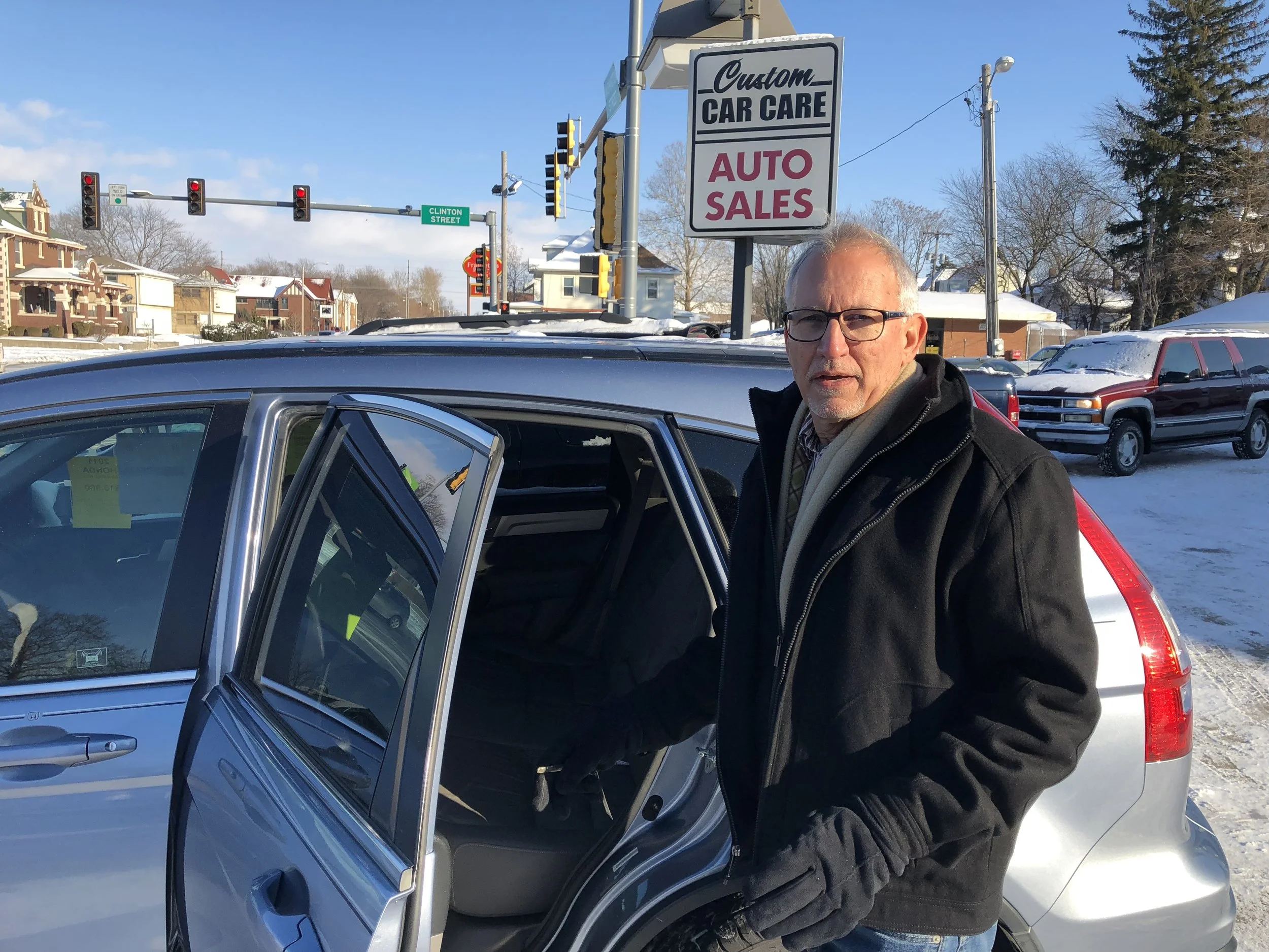 Pete Hettinger shows off a Honda CR-V in the Custom Auto Sales parking lot (Credit: Erik Prenzler)