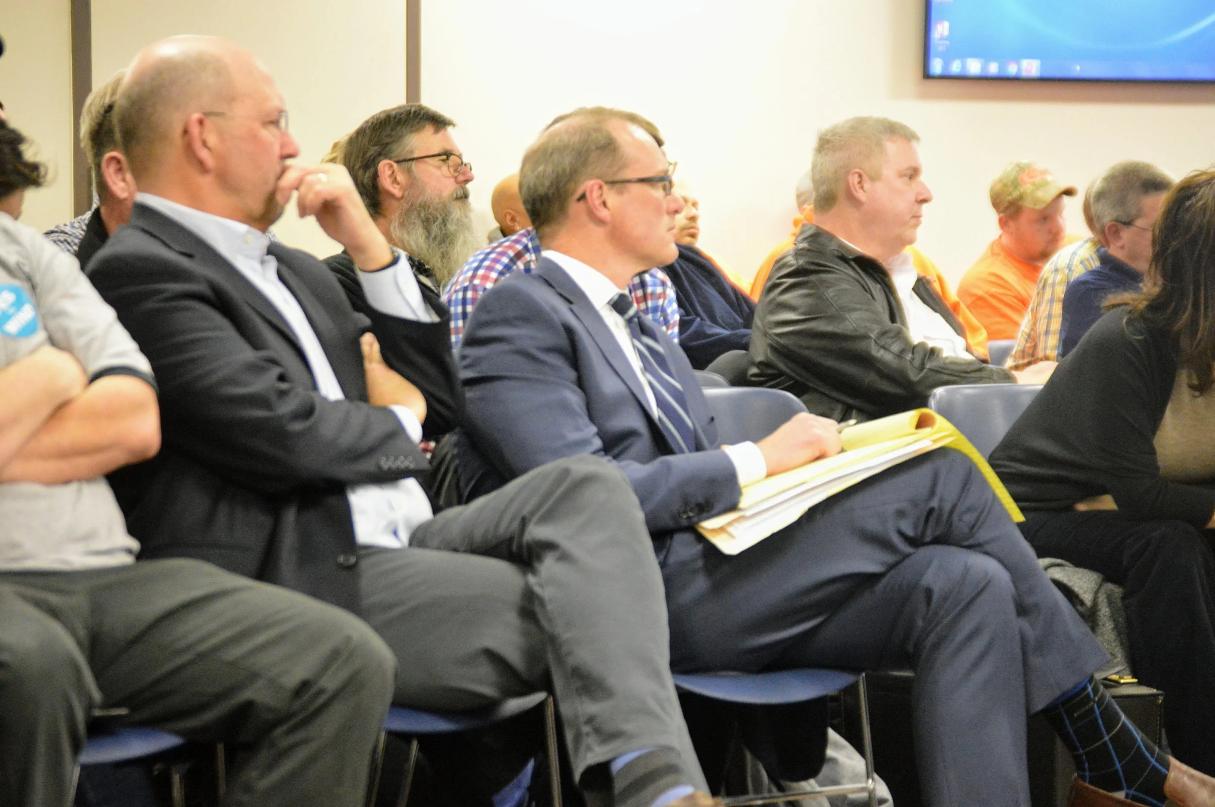 Invenergy executives listen to public testimony at a hearing Tuesday evening at the Government Center. (Image credit: Breanna Grow for AdaptBN)