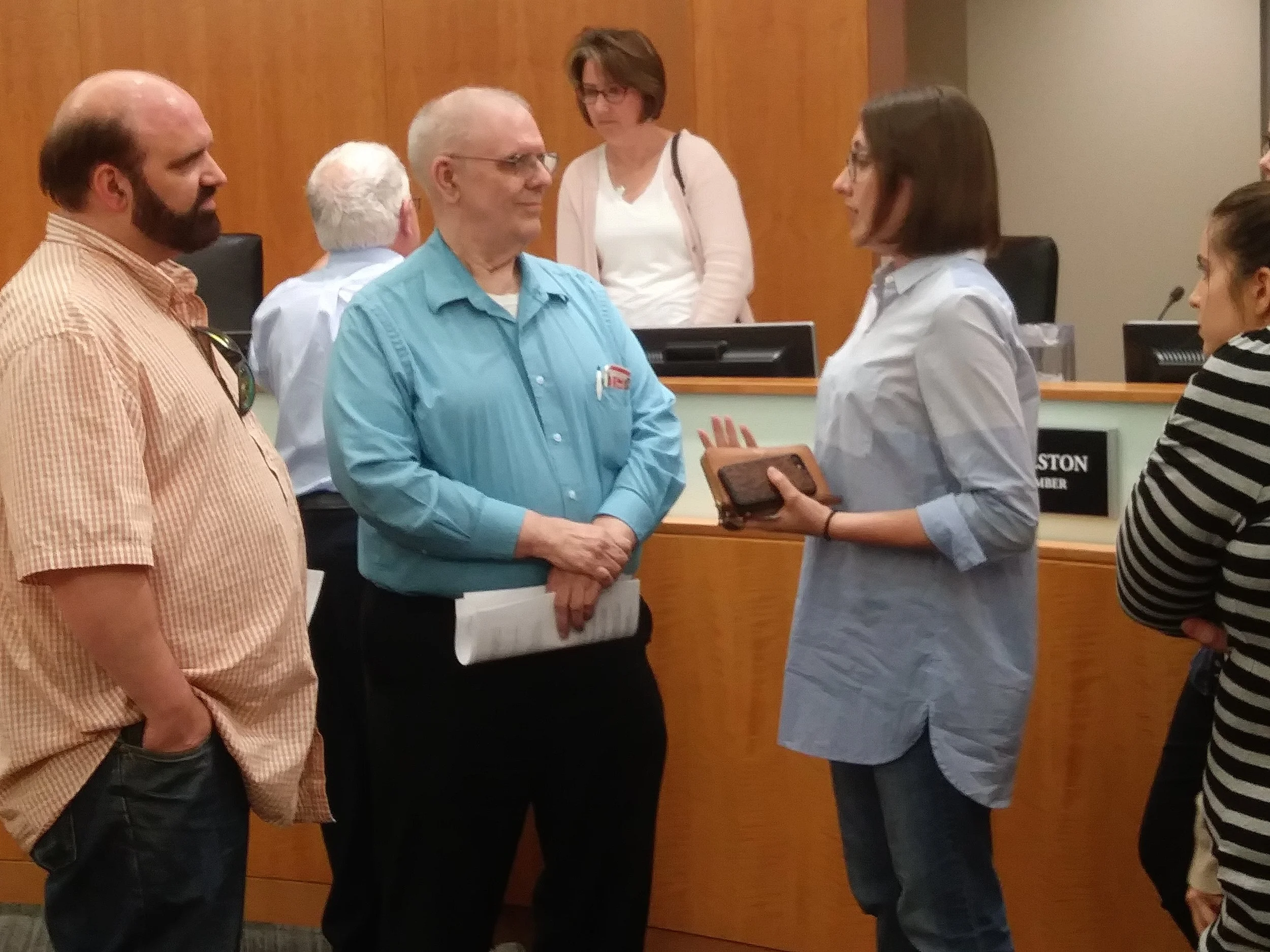 Normal property owners Karl and Charles Sila talk with Illinois State University students after Town Council members approved a multi-family recycling ordinance Monday night. (Photo: Breanna Grow) 