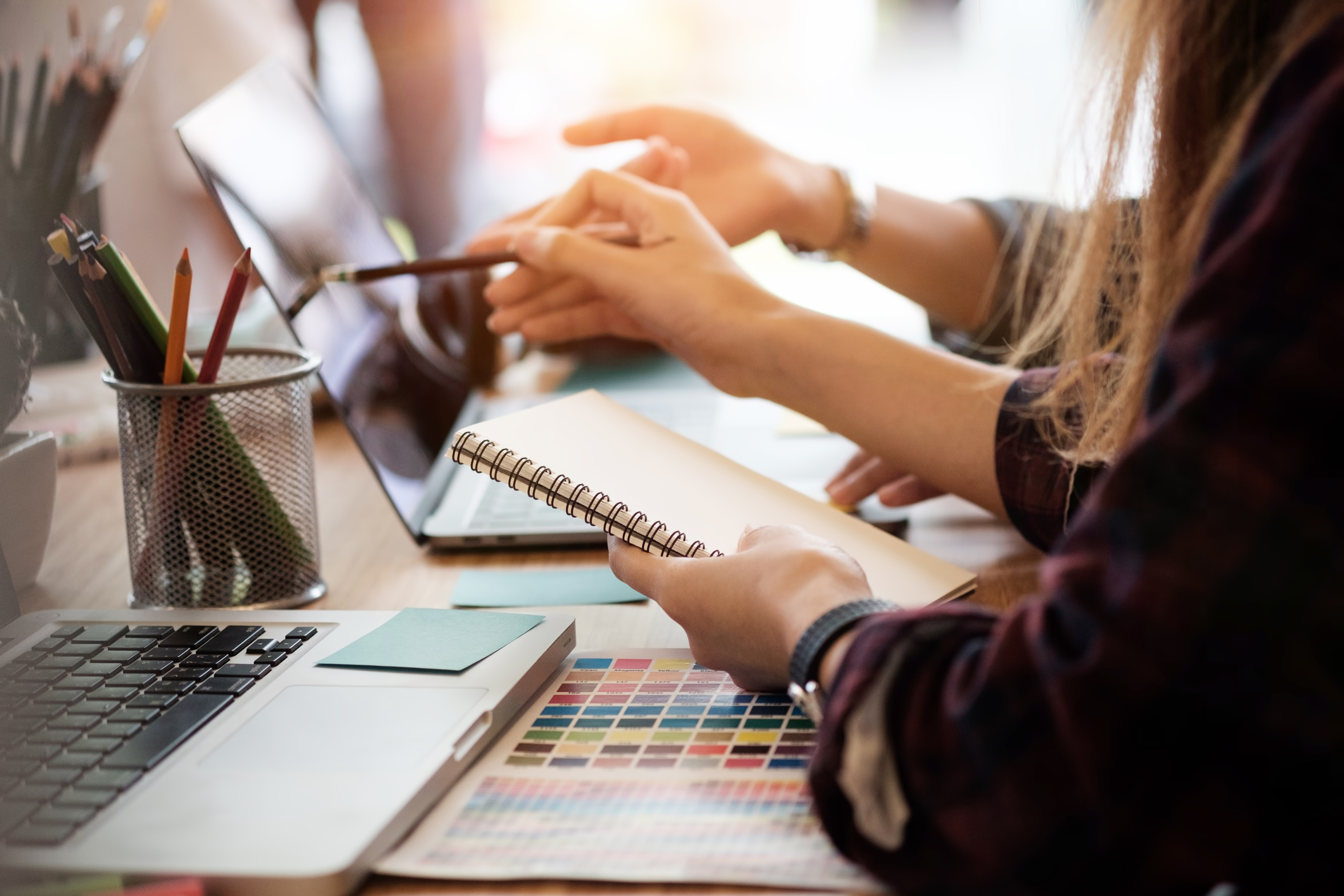 Creative-team-two-woman-working-with-computer-in-modern-office,-selective-hands-hold-notebook-paper.-925712824_2125x1417.jpeg