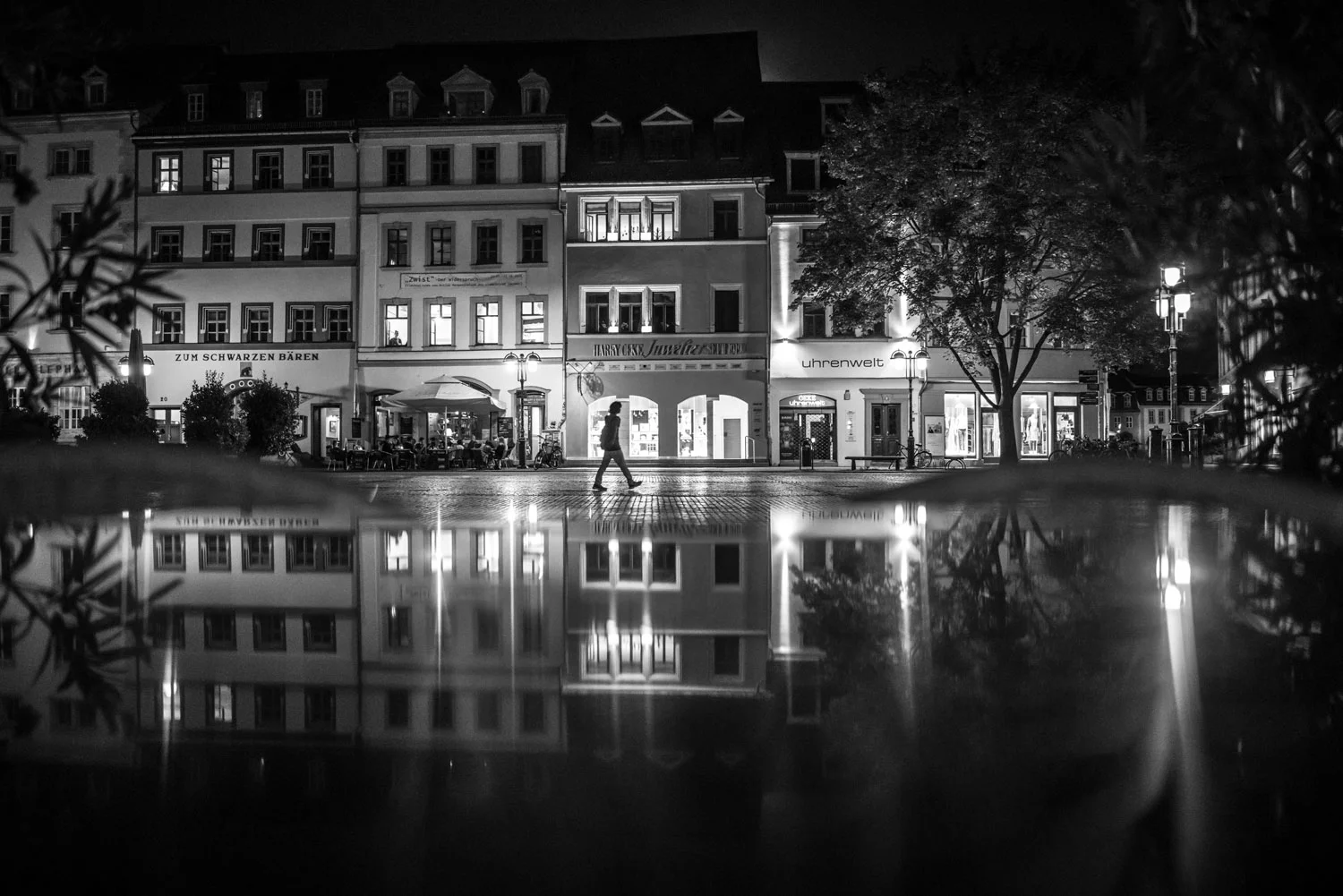 Weimarer Marktplatz bei Nacht. Die Spiegelung entsteht durch eine Metalltischplatte.