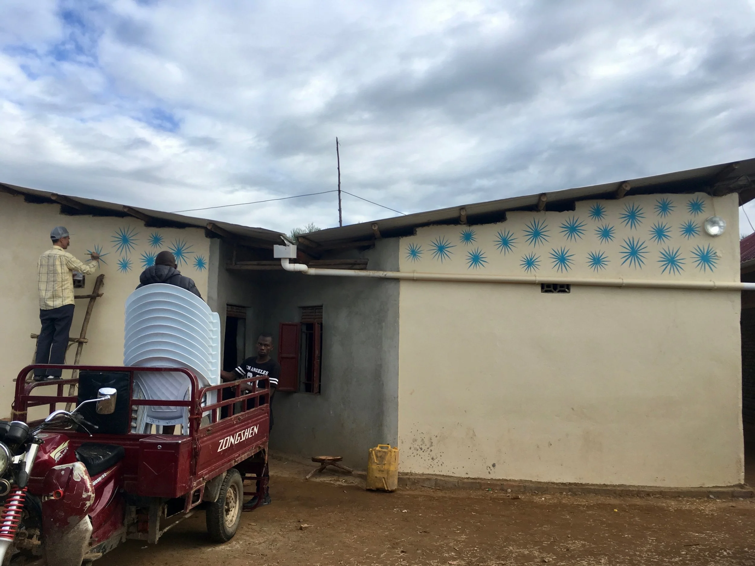 Rain catchment roof with pipe leading to barrels at Opportunigees in Nakivale Settlement