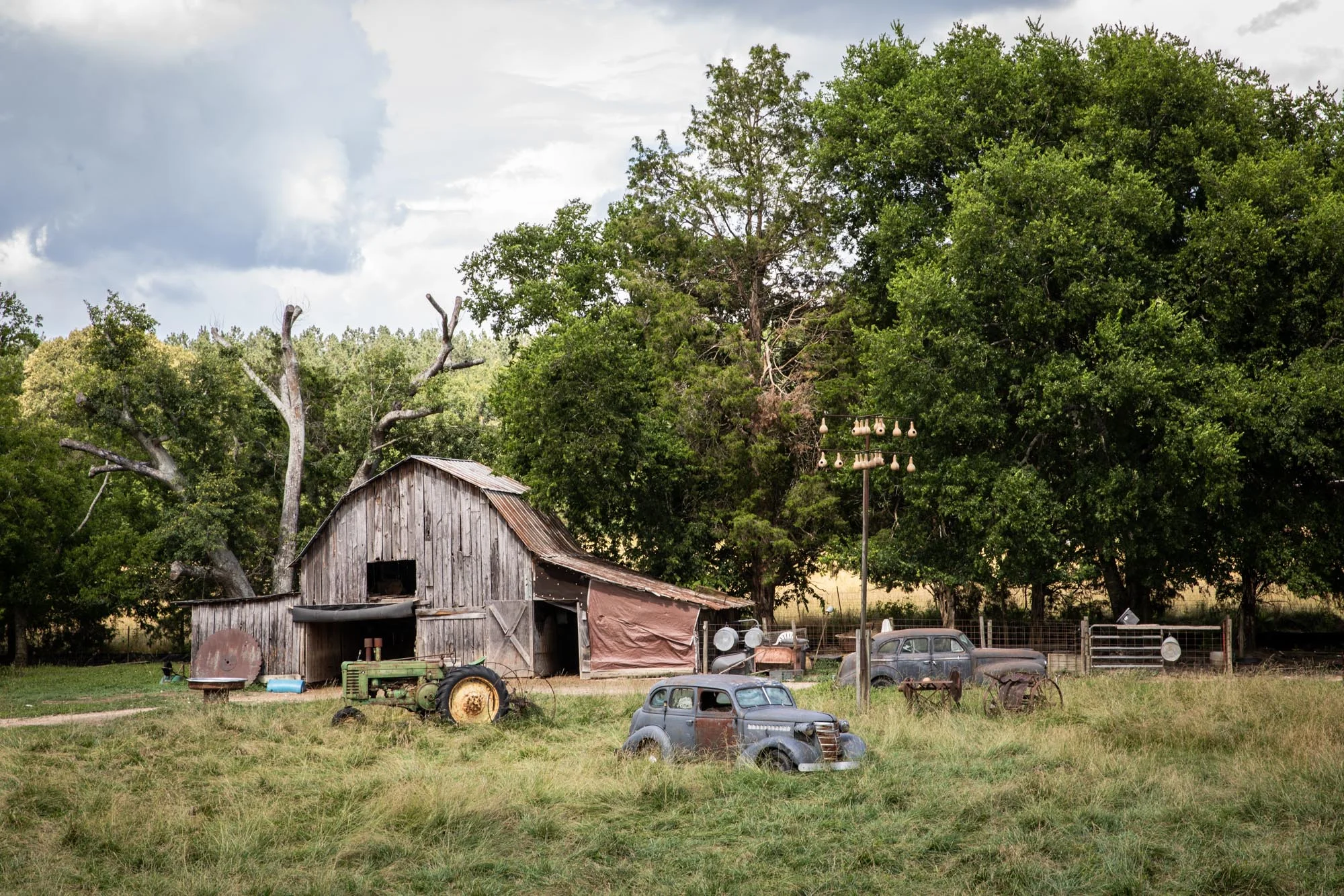 An old farm with goats and chickens roaming around amongst the old cars and tractor along Hwy 27.