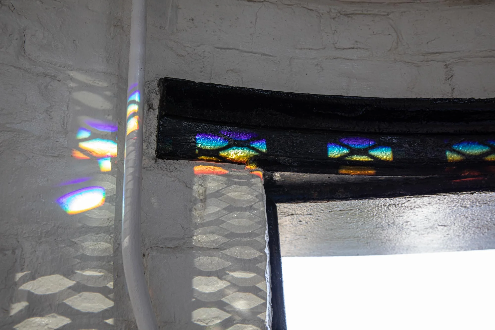 At the top of the stairs, just before going out on the balcony, the sun light was detracted by the prisms in fresnel lens.