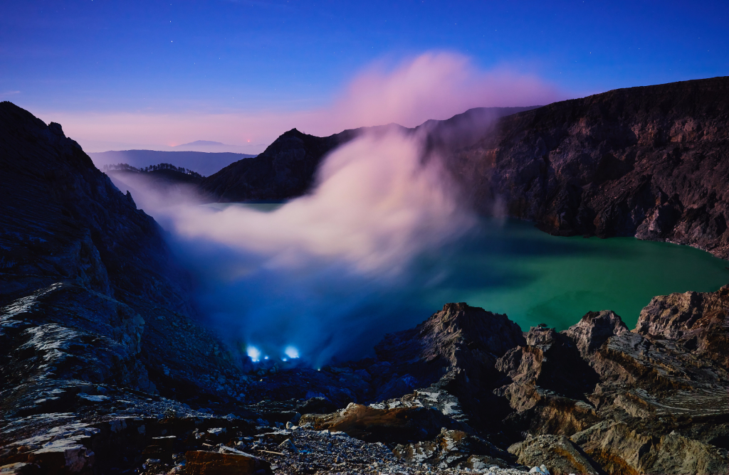 Kawah Ijen volcano crater lake with blue flame and sulfuric smoke view with sunrise dawn morning.
