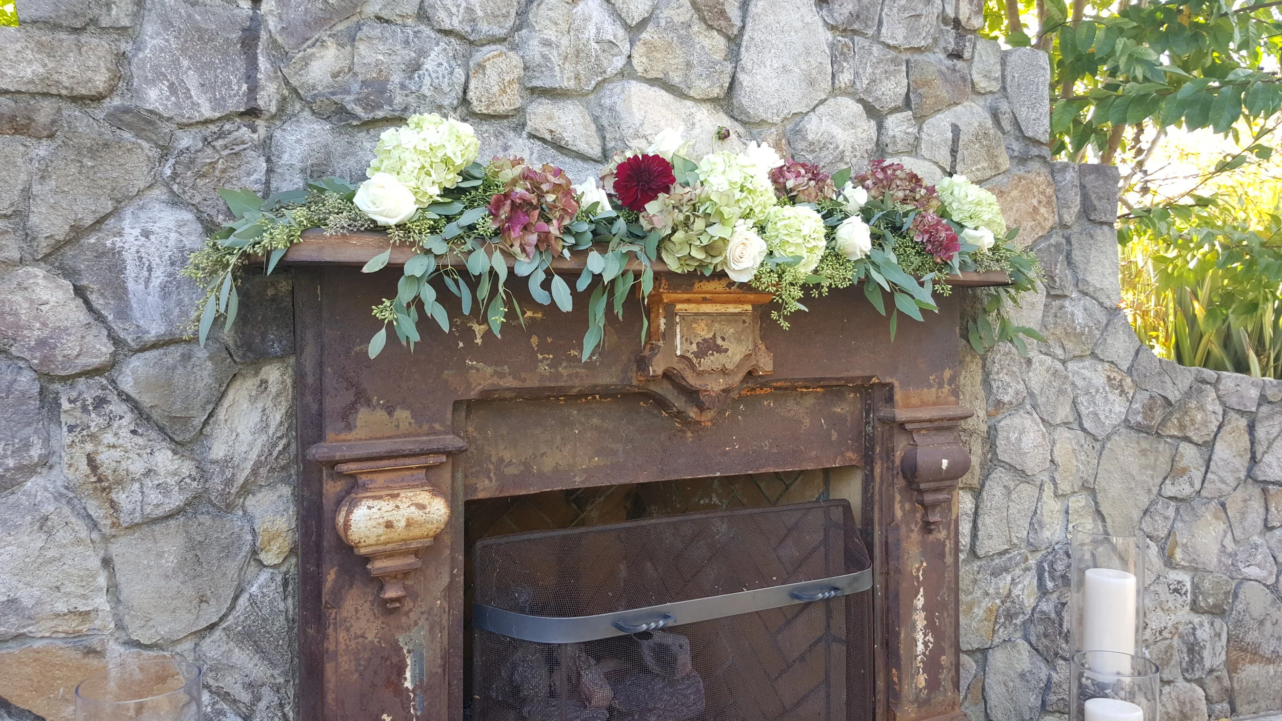 Fireplace decor General's Daughter. Bold flower colors nestled in lush green eucalyptus garland.