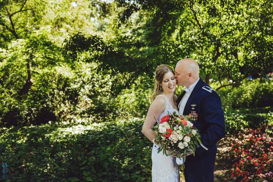 Lush gardens and sweeping lawns at Madrona Manor in Healdsburg. Bouquet of flowing green foliage with pops of bright coral ranunculus mixed with soft blush garden roses. 