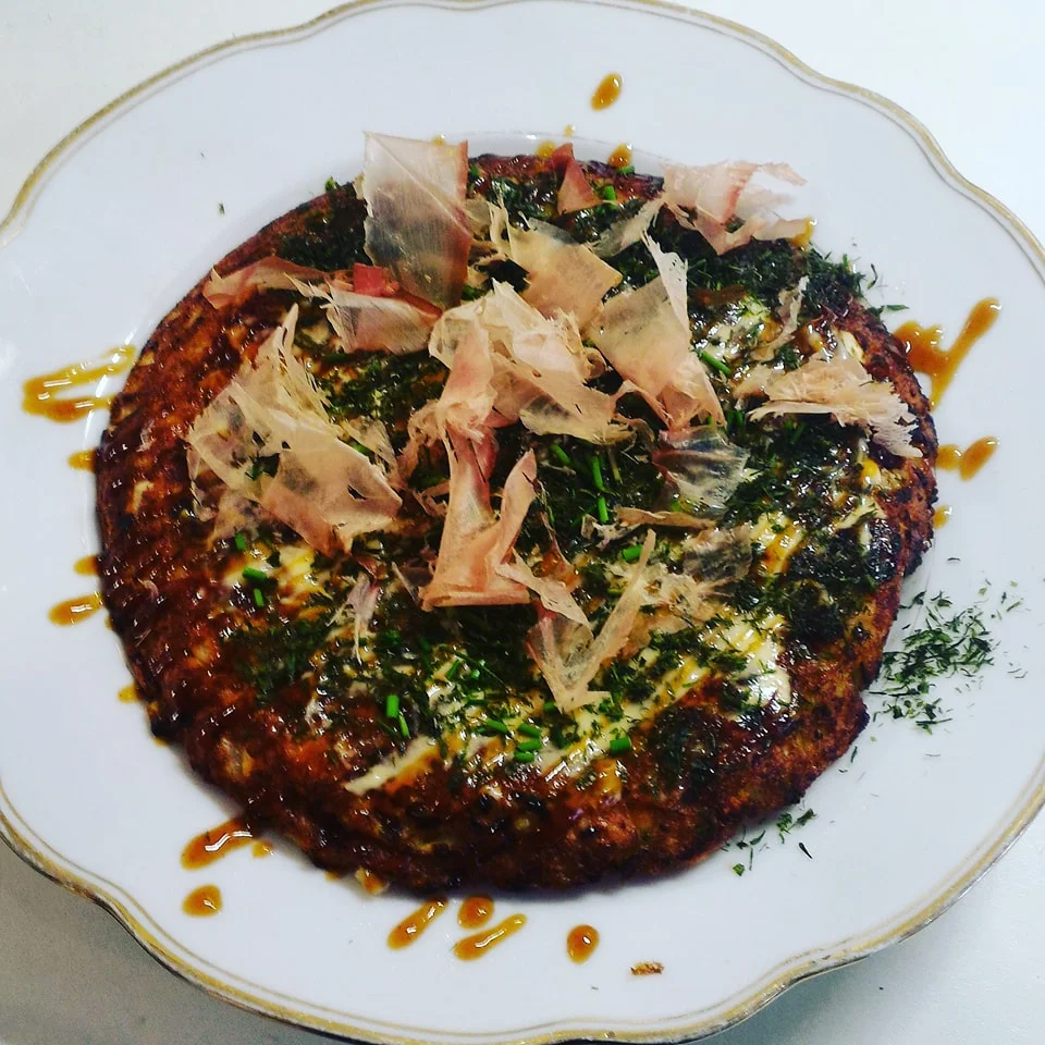 A homemade okonomiyaki made partly by yours truly (shoutout Giulia!). It's a savory pancake with seafood (or other fillings of your choice) and topped with bonito flakes, mayo, and a special okonomiyaki sauce.