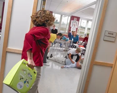 picture-woman-carrying-aed-to-emergency-simply-first-aid-ltd.jpg