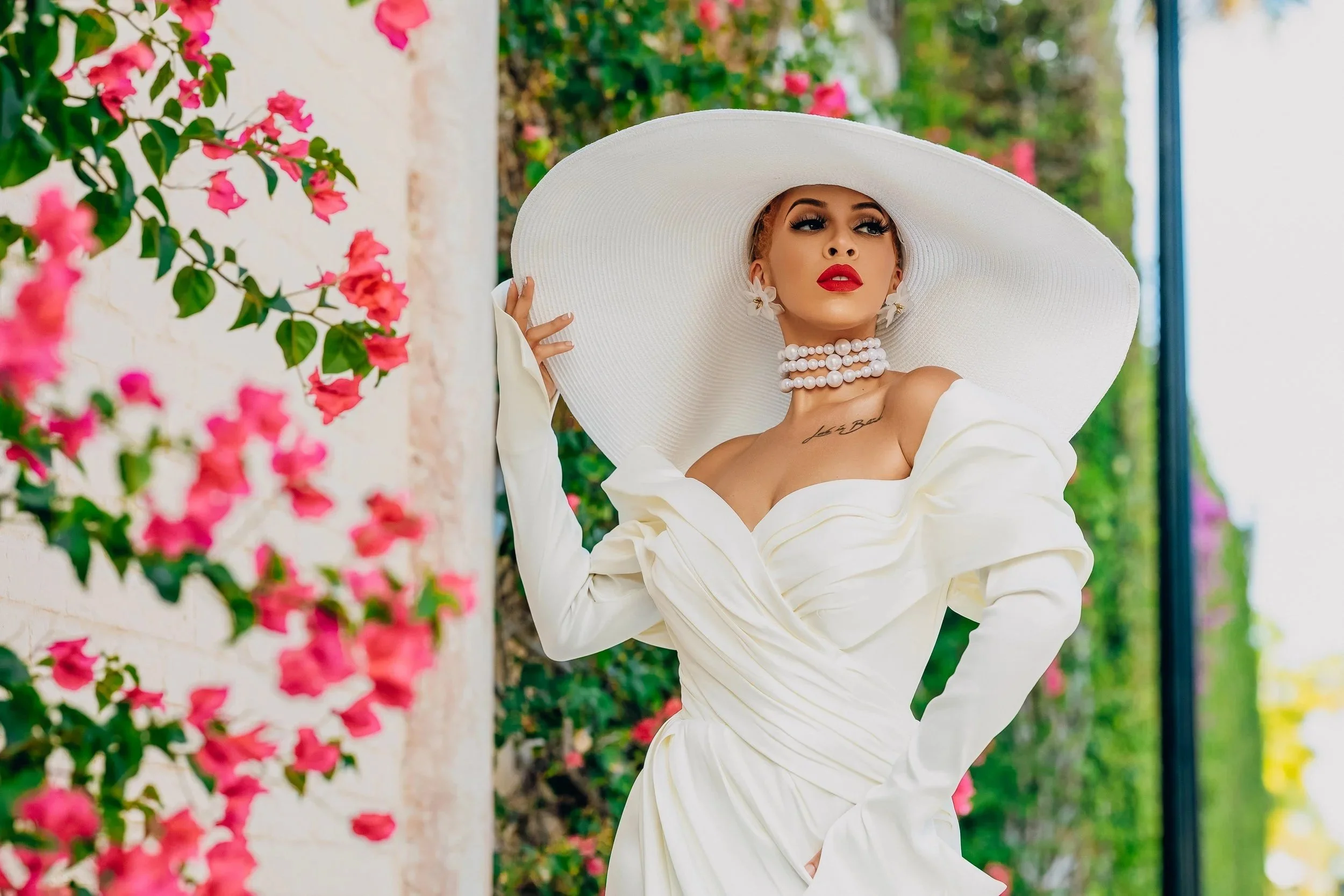 Bride in a wide-brim white hat among bougainvillea near Worth Avenue - West Palm Beach wedding photographer Topflash Photography