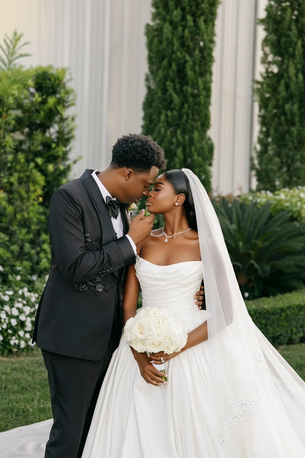 Bride and groom standing beneath a white gazebo, photographed by Topflash Photography