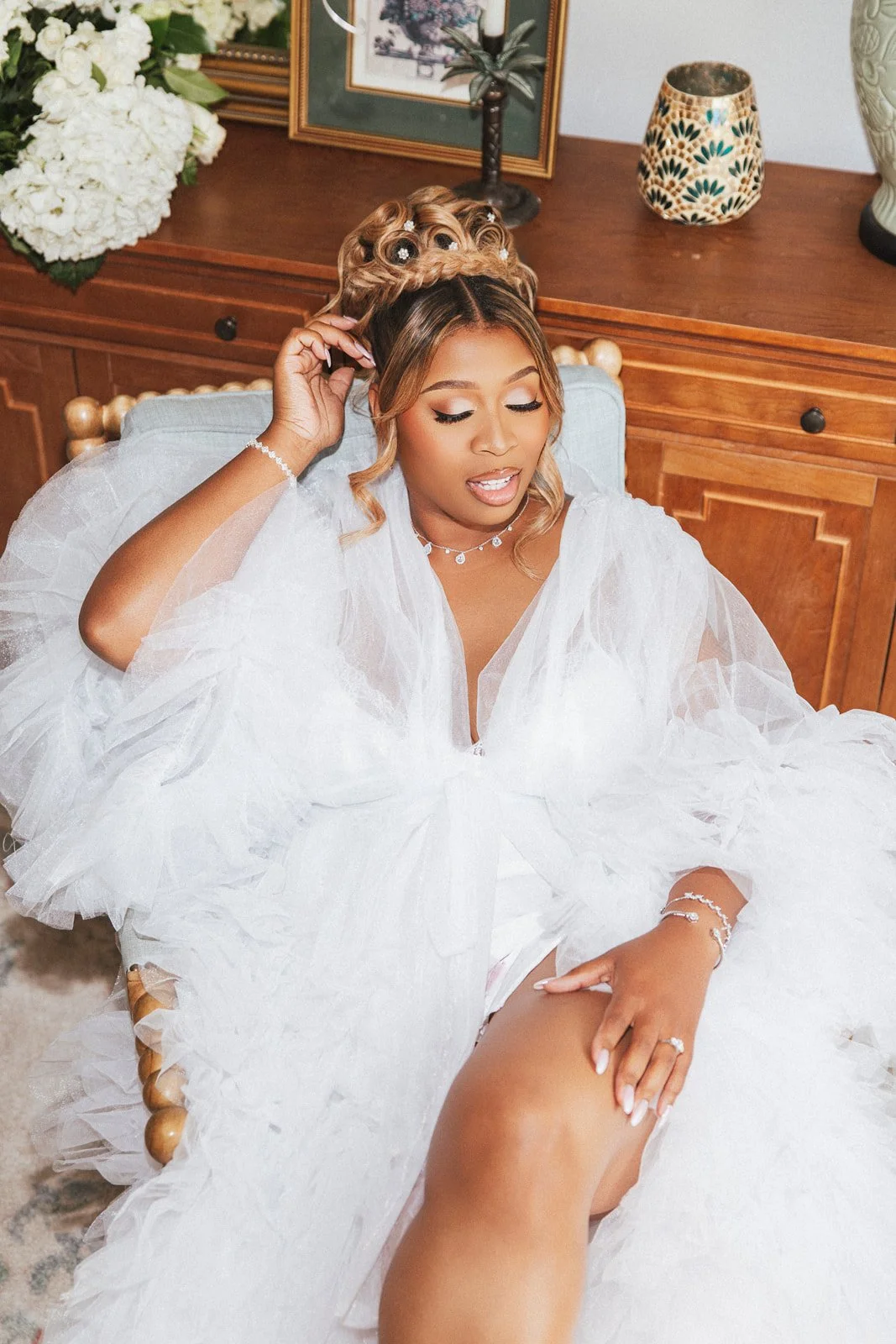 Bride in a white feathered outfit getting ready indoors, photographed by Topflash Photography
