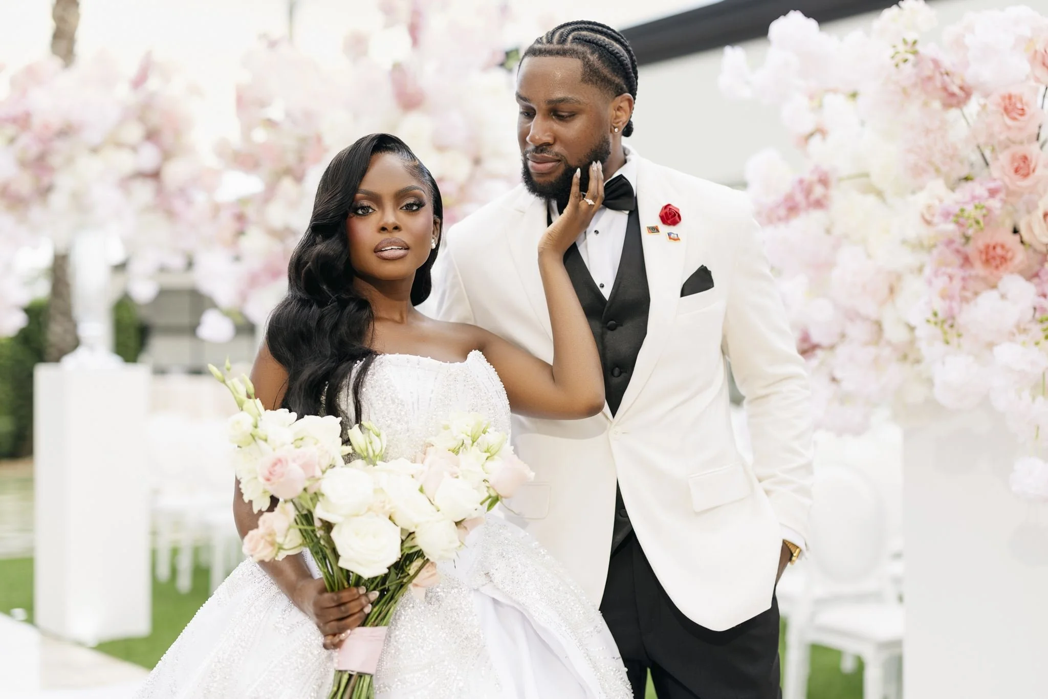 Bride and groom posing among pink roses, photographed by Topflash Photography