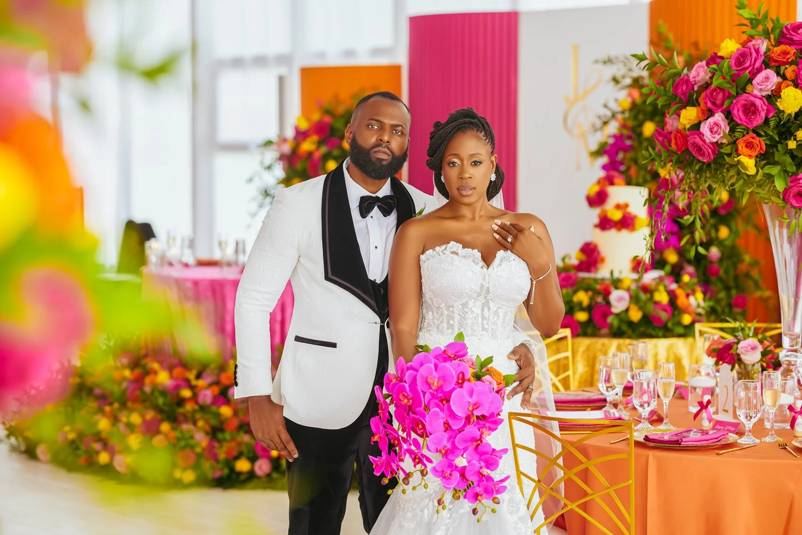 Bride and groom at a colorful pink and orange wedding reception, photographed by Topflash Photography