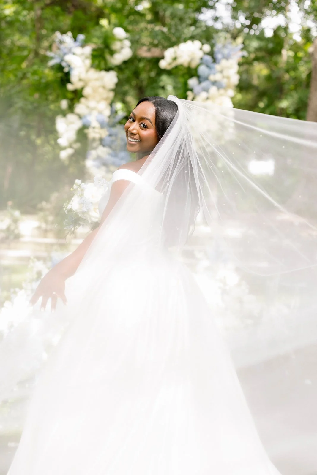 Bride in a white gown walking through a leafy garden, photographed by Topflash Photography