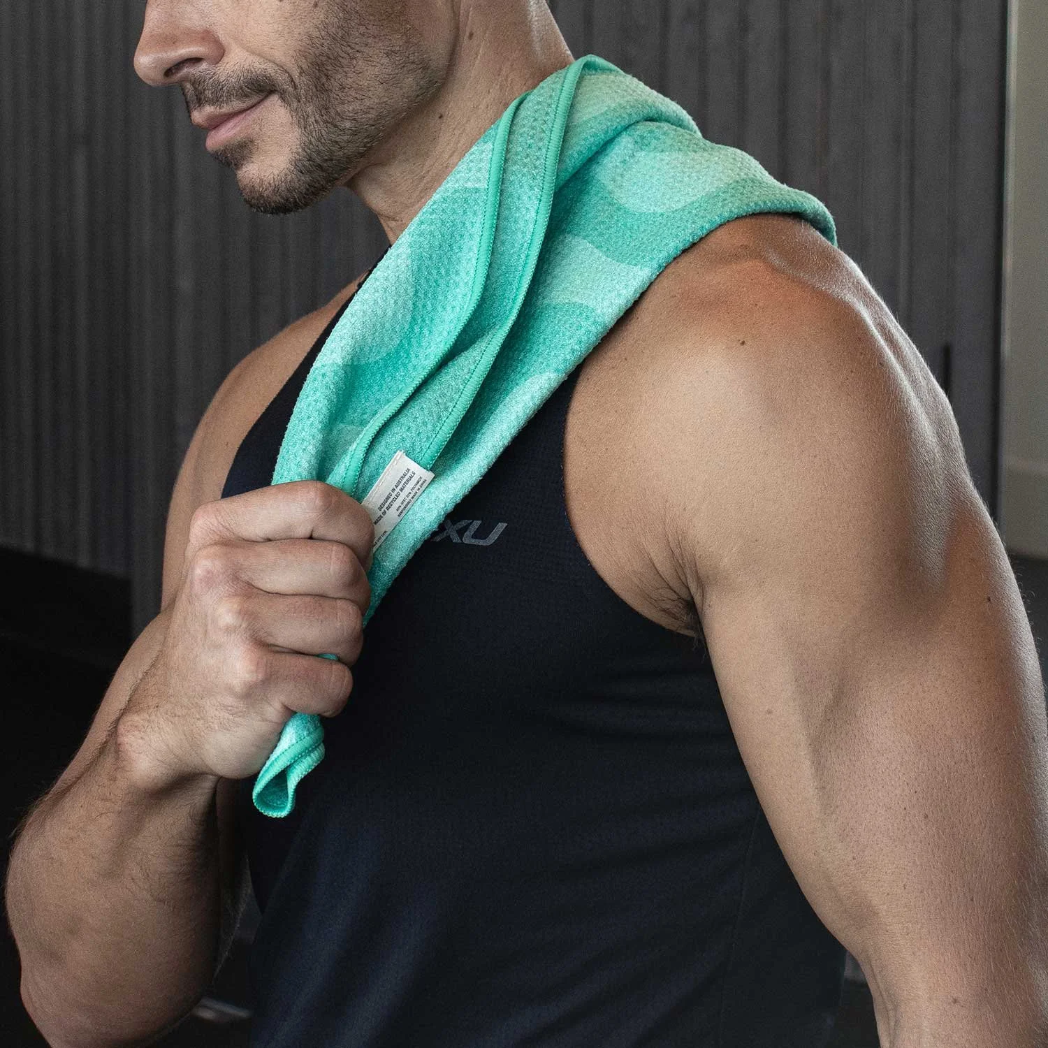 Male fit model using the eco gym towel, draped over his shoulder. Ocean Mint towel displayed.