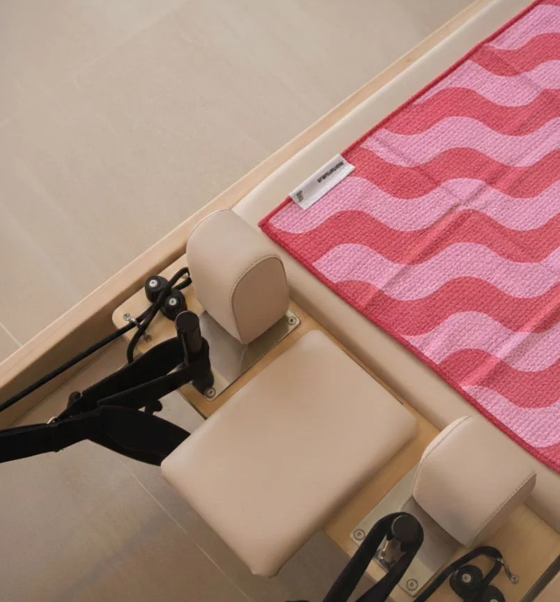 Compact PRO-DRI reformer Pilates towel on reformer carriage, designed for grip, hygiene and quick drying.