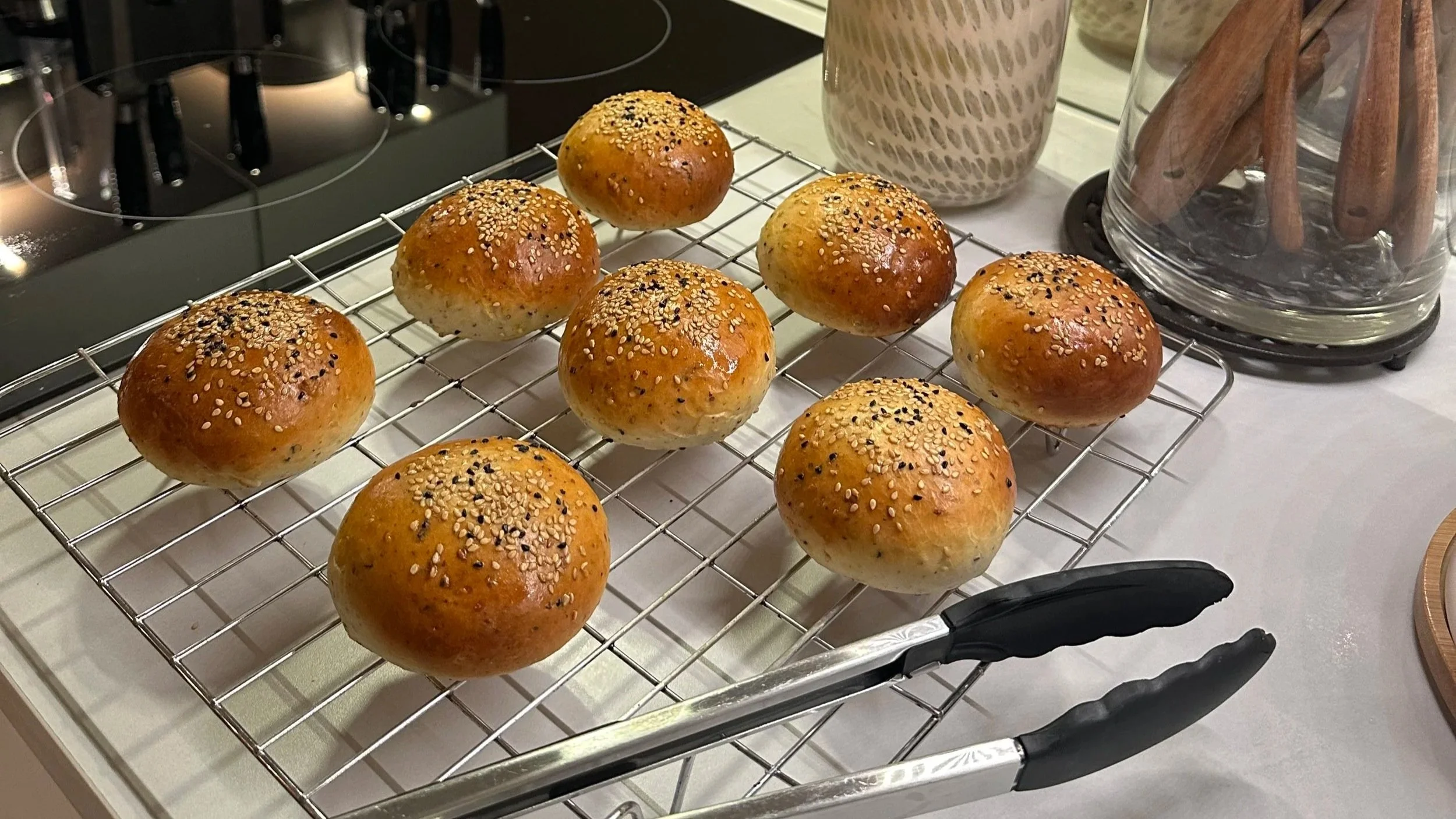 Golden brioche buns topped with sesame & kalonji seeds on kitchen counter
